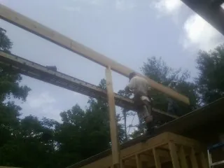 Carpenter setting a ridge beam over a new addition frame — Ice Dam Removal by Roofing Brothers in Connelly