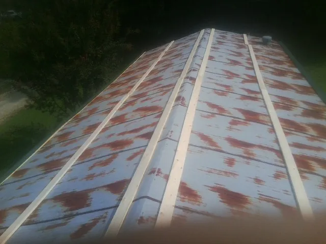 Rusted metal roof panels with new wood purlins before replacement — Storm Damage Roof Repair in Connelly by Roofing Brothers