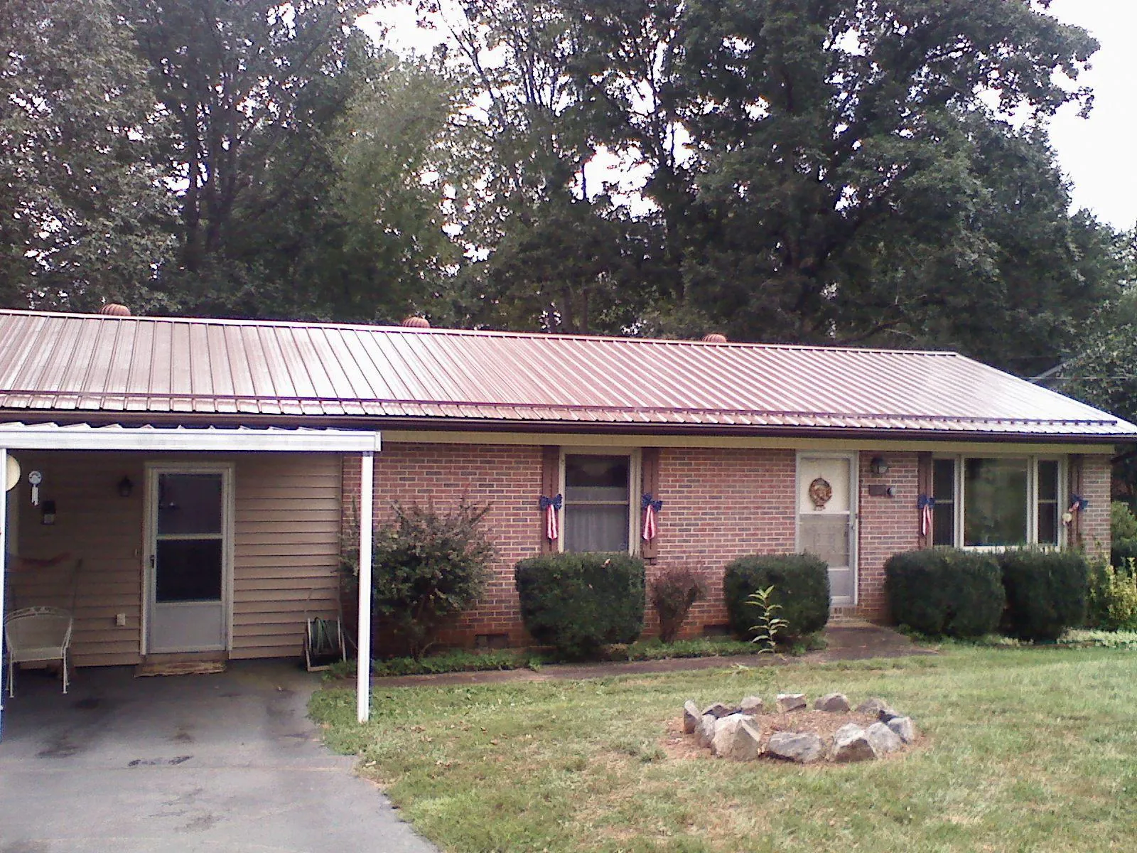 Bronze metal roof and carport on a brick ranch home — Roof Repair work by our crew in Connelly